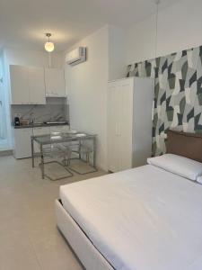 a bedroom with a bed and a table and a kitchen at Duca d Aosta apartment 3 in Monfalcone