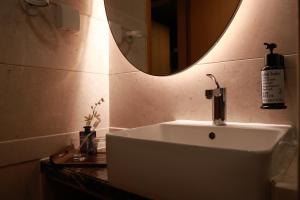 a bathroom with a white sink and a mirror at Dan Executive Apartment Guangzhou Zhujiang New Town in Guangzhou +55 photos