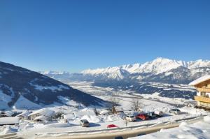 un villaggio ricoperto di neve con montagne sullo sfondo di Chalet Edelweiss a Weerberg