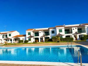 a swimming pool in front of a building at Cala Porter Soleil & Mer Collection in Cala en Porter