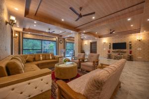 a large living room with couches and a tv at A Mountains Suffer Hotel Kasauli Near Kasauli Hills Resort by Splendid Retreat Hotels - Family Groups - Balcony - Parking - Mountain View - River View - Forest Treks - Vacation - Memories in Kasauli