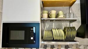 a kitchen with a microwave and a shelf with dishes at I Racconti del Fiume in Bussi sul Tirino