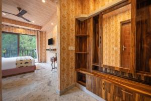 a bedroom with wooden walls and a bed with a window at A Mountains Suffer Hotel Kasauli Near Kasauli Hills Resort by Splendid Retreat Hotels - Family Groups - Balcony - Parking - Mountain View - River View - Forest Treks - Vacation - Memories in Kasauli