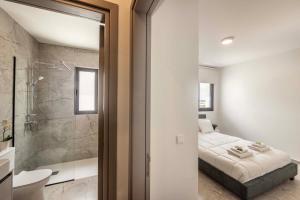 a bedroom with a bed and a bathroom with a shower at Lake View Suites in Paralimni +255 photos