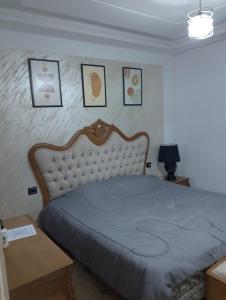 a bed in a bedroom with pictures on the wall at Moussaoui house in Aïn Draham