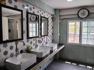 a bathroom with two sinks and two mirrors at Yoosabai Hostel And Guesthouse in Bangkok +19 photos