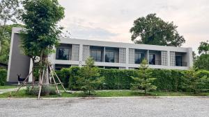 a white building with trees in front of it at The Camp in Kanchanaburi City