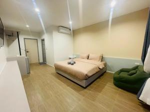 a bedroom with a bed and a green couch at The Camp in Kanchanaburi City