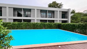 a swimming pool in front of a building at The Camp in Kanchanaburi City
