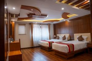 a hotel room with two beds and a window at Hotel Kailash Kutee in Kathmandu +92 photos