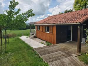 a small wooden cabin with a wooden deck at Les chalets du Causse Confort Climatisé in Gelle