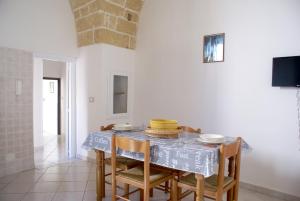 a dining room with a table and some chairs at Corte De Noie Appartamenti Gallipoli in Gallipoli