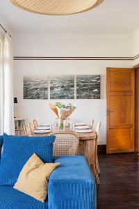 a dining room with a table and a blue couch at LA PINÈDE - Villa 4 étoiles vue mer - Plage à 30 m - Emplacement exceptionnel in Dinard +36 photos