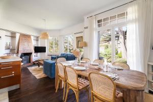 a dining room and living room with a table and chairs at LA PINÈDE - Villa 4 étoiles vue mer - Plage à 30 m - Emplacement exceptionnel in Dinard