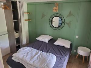 a small bedroom with a bed and a mirror at Les chalets du Causse Confort Climatisé in Gelle