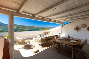 a dining room with a table and chairs on a balcony at MH Suites in Olbia