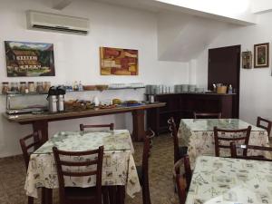 a kitchen with two tables and chairs and a counter at Hotel Nossa Senhora do Carmo in Ilha Comprida