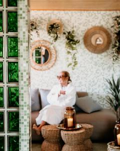 a woman sitting on a couch in a living room at Villa Brunnby in Mölle