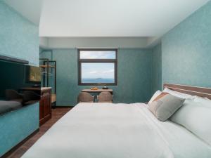 a bedroom with a large white bed and a window at The Zen in Jiufen