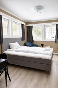 a large bed in a room with windows at Storebaug Motell in Moss +4 photos