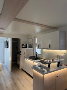 a kitchen with white cabinets and a counter top at JungleHouse - Floating House in Portorož