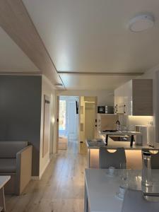 a kitchen and living room with tables and chairs at JungleHouse - Floating House in Portorož