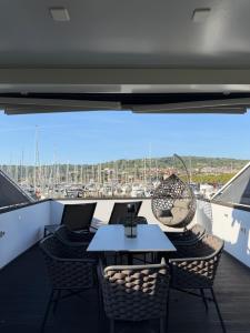 a balcony with a table and chairs on a ship at JungleHouse - Floating House in Portorož