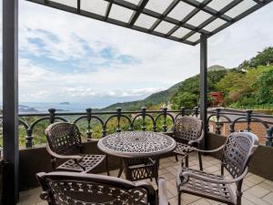 a table and chairs on a balcony with a view of the ocean at The Zen in Jiufen