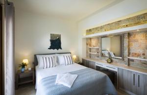 a bedroom with a large bed and a mirror at Muses Beach Villas - Urania in Sitia