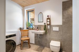 a bathroom with a sink and a washing machine at Chalet Bergblick in Rimsting +37 photos