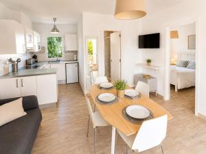 a kitchen and a living room with a table and chairs at Cala Porter Soleil & Mer Collection in Cala en Porter