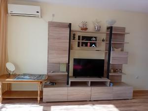 a living room with a tv on a wooden entertainment center at Студио Ахелой in Aheloy