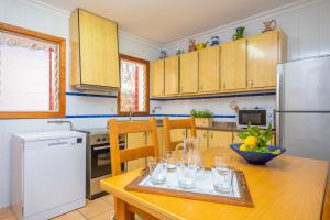 a kitchen with a wooden table with glasses on it at Can Pons in Can Picafort +17 photos