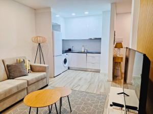 a living room with a couch and a table and a kitchen at Timeless Beach V - Apartment in Armação de Pêra