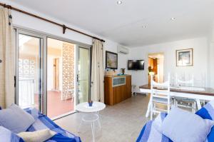 a living room with a blue couch and a table at Can Vesses in Alcudia