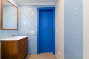 a bathroom with a blue door and a sink at Can Vesses in Alcudia +19 photos