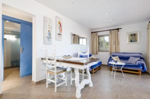 a living room with a table and a blue couch at Can Vesses in Alcudia