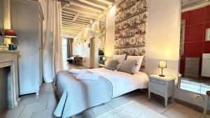 a bedroom with a large white bed and a fireplace at Le Nid de la Loire - Centre historique - 4 pers - Classé 3 étoiles in Blois