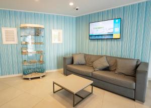 ein Wohnzimmer mit Sofa und Flachbildfernseher in der Unterkunft BLUESEA Cala Millor in Cala Millor