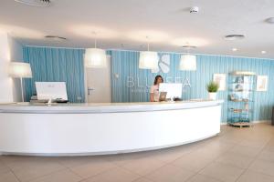 Eine Frau steht an einem Tresen in einer Zahnarztpraxis. in der Unterkunft BLUESEA Cala Millor in Cala Millor