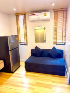 a blue couch in a room with a refrigerator at Adventure Studio Aonang in Ao Nang Beach +2 photos