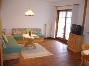 ein Wohnzimmer mit einem Sofa und einem Tisch in der Unterkunft Hermeshof und Biohaus in Titisee-Neustadt