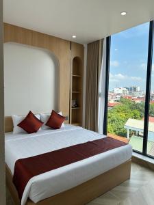 a bedroom with a large bed with a large window at Trang An Harmony Hotel in Ninh Binh