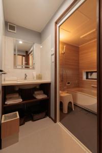 a bathroom with a tub and a sink and a toilet at 伊根の舟屋 樹 Funaya Inn Tatsuki , Ine in Kameshima +32 photos