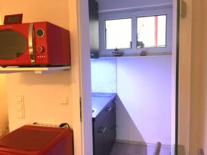 eine kleine Küche mit einer Mikrowelle und einem Fenster in der Unterkunft Apartment Warnemünde 16 in Warnemünde