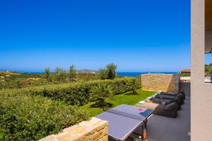 a patio with tables and chairs and the ocean at Villa Reale - Wellness & Refined Living by etouri in Chania +78 photos