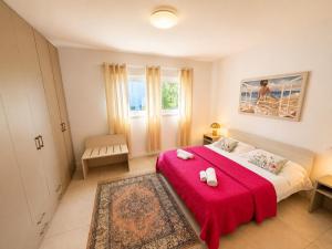 a bedroom with a large bed with a red blanket at Villa Greif Apartment in Lignano Sabbiadoro +31 photos