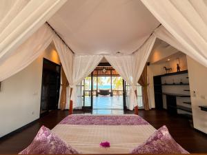 a bedroom with a large bed in a room at BougainVilla - Oceanfront villa with Cook, ideal for Weddings and Events in Keramas