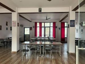 a dining room with tables and chairs and red curtains at Beas Zayaka - Hotel & Cafe in Pāndoh