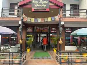 a man walking out of a restaurant at Beas Zayaka - Hotel & Cafe in Pāndoh